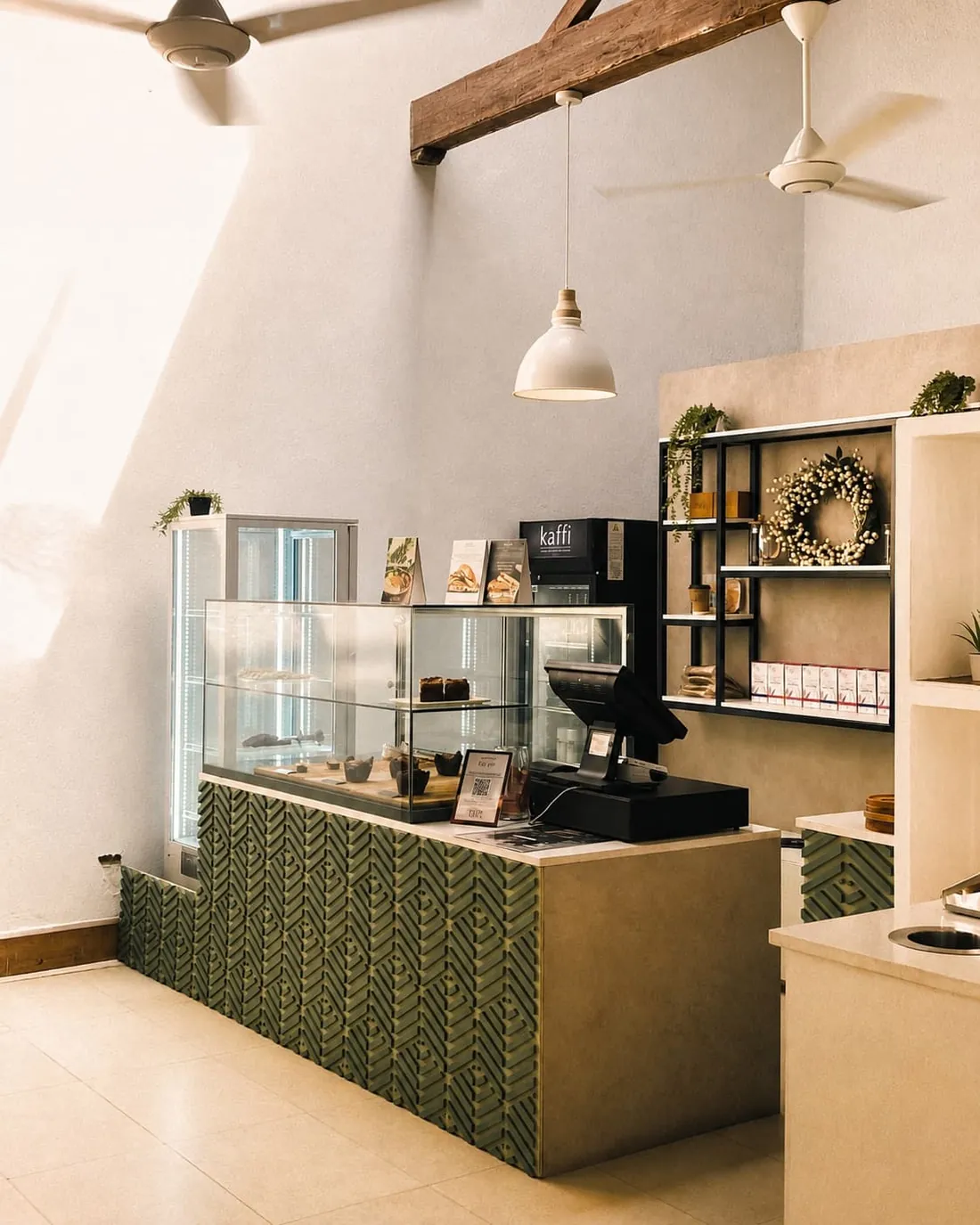 The service counter at Kaffi Galle Fort, green chevron tiles below a glass pastry case.